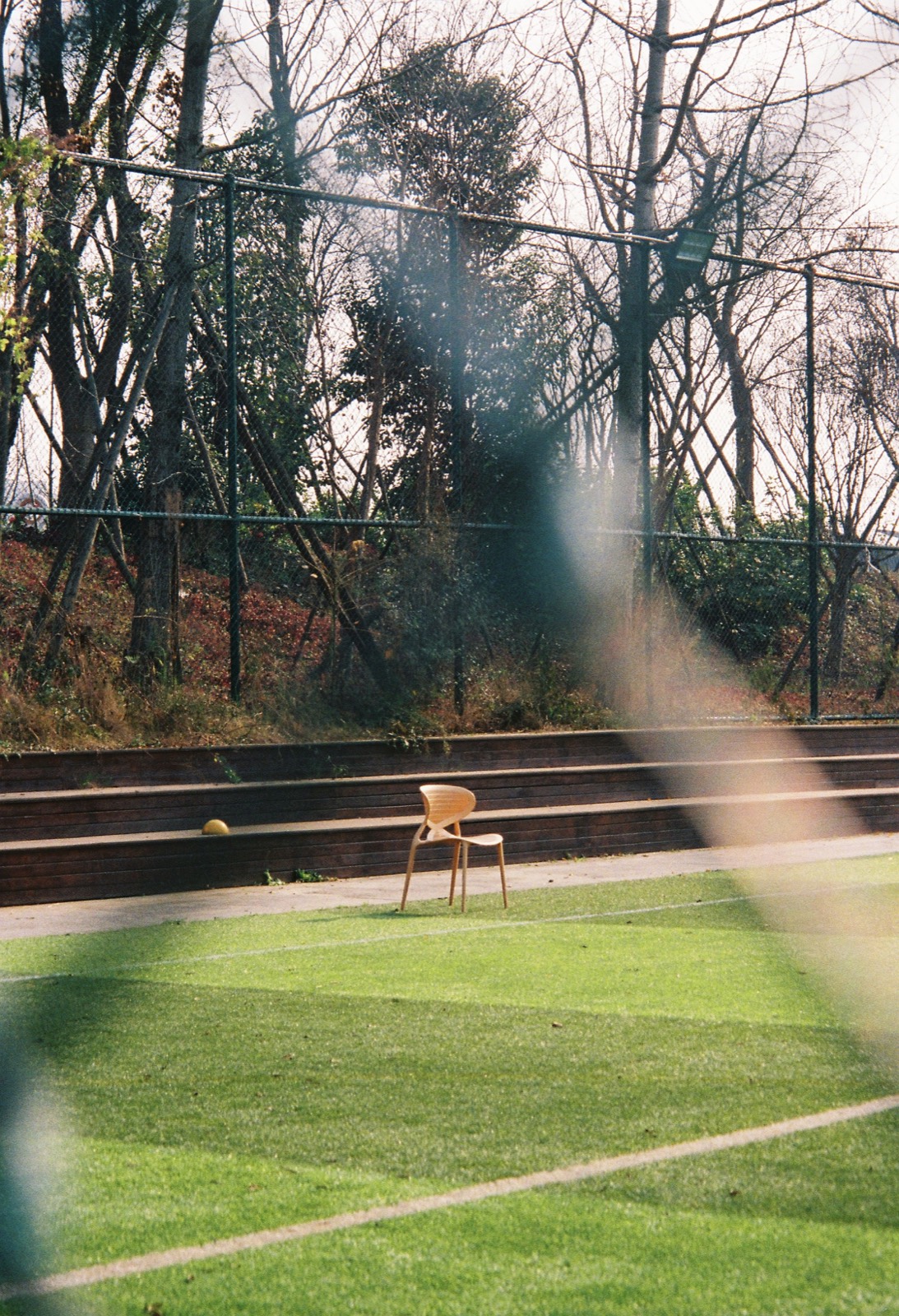 An empty chair beyond a reflective window